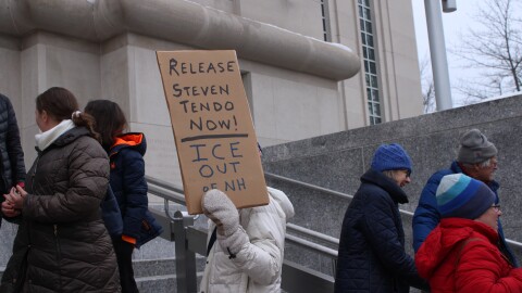 About a dozen supporters of Steven Tendo, a Vermont Pastor and asylum seeker from Uganda, stand outside the federal courthouse in Concord ahead of his hearing on Friday, Feb. 20, 2026.