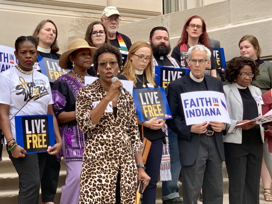 Shonda Nicole Gladden, holding the microphone, speaks on the Indiana Statehouse steps with members of Faith in Indiana.