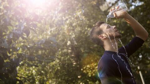 A man pouring water onto his fac