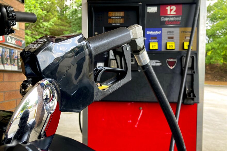 A man fills his mototcycle fuel tank, Thursday, June 23, 2022, in Kennesaw, Ga. This week, it's averaging $4.95 per gallon nationwide, up from $3.06 per gallon a year ago, according to AAA. (AP Photo/Mike Stewart)