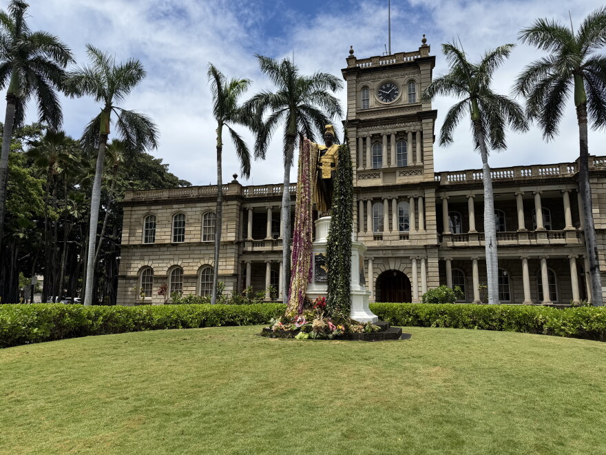 Ornate building with palm trees and gold-leaf statue covered in le