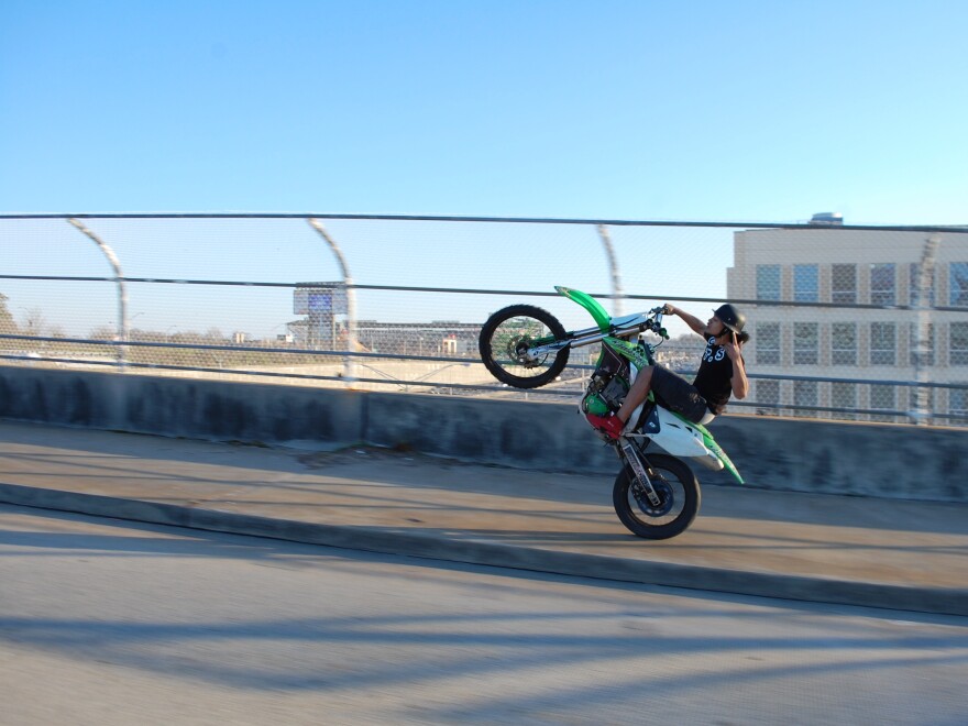 A dirt biker "popping a wheelie".