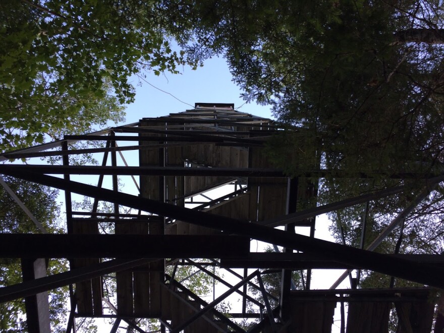 A view looking up at the underside of a fire tower. 