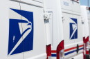 FILE - Delivery vans are parked during a protest staged as part of a countrywide National Day of Action Tuesday, July 28, 2026, outside the main United States Postal Service headquarters in northeast Denver.