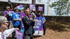 Daniel Tucker, a leader with the Missouri Workers Center, teaches chants customized to an initiative petition to raise the minumum wage and mandate paid sick leave outside of the Secretary of State's office building in Jefferson City Wednesday.