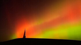 The northern lights fill the sky behind the Saint Joseph the Woodworker Shrine Tuesday, Nov. 11, 2025, near Valley Falls, Kan. (AP Photo/Charlie Riedel)