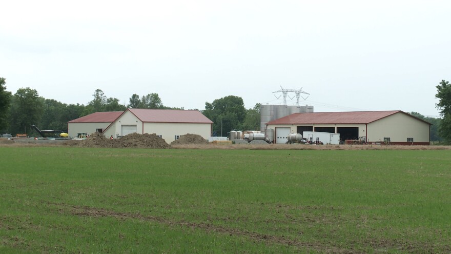 Three building with red roofs in a field.