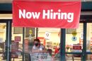 A Now Hiring sign hangs near the entrance to a Winn-Dixie Supermarket in Hallandale, Florida.