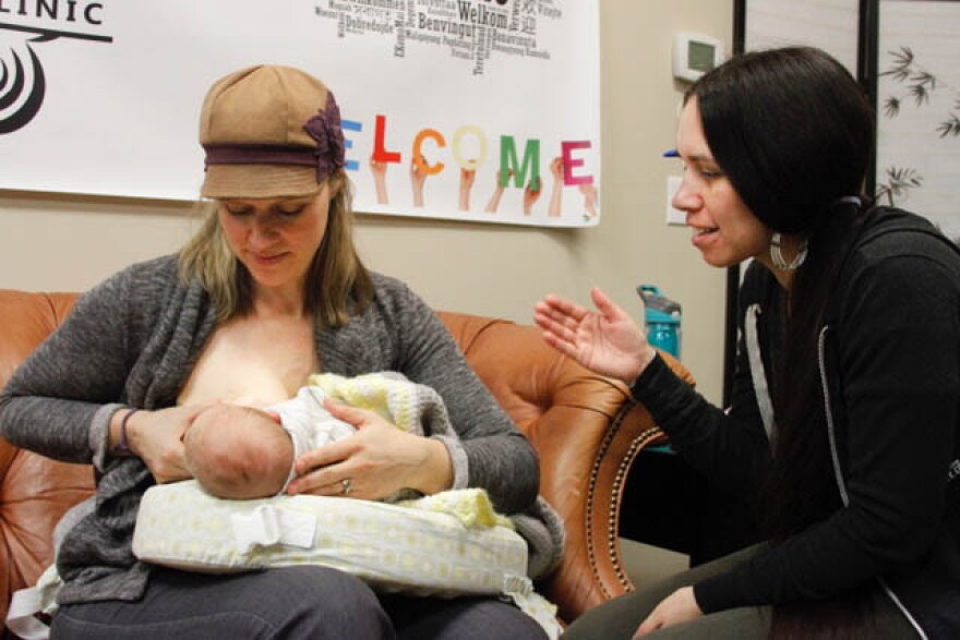 Lactation consultant Camie Goldhammer helps 5-week-old Darius latch onto his mother, Carole Gibson-Smith. Goldhammer, a social worker by training, focuses on breastfeeding in communities of color, particularly in Native communities. 