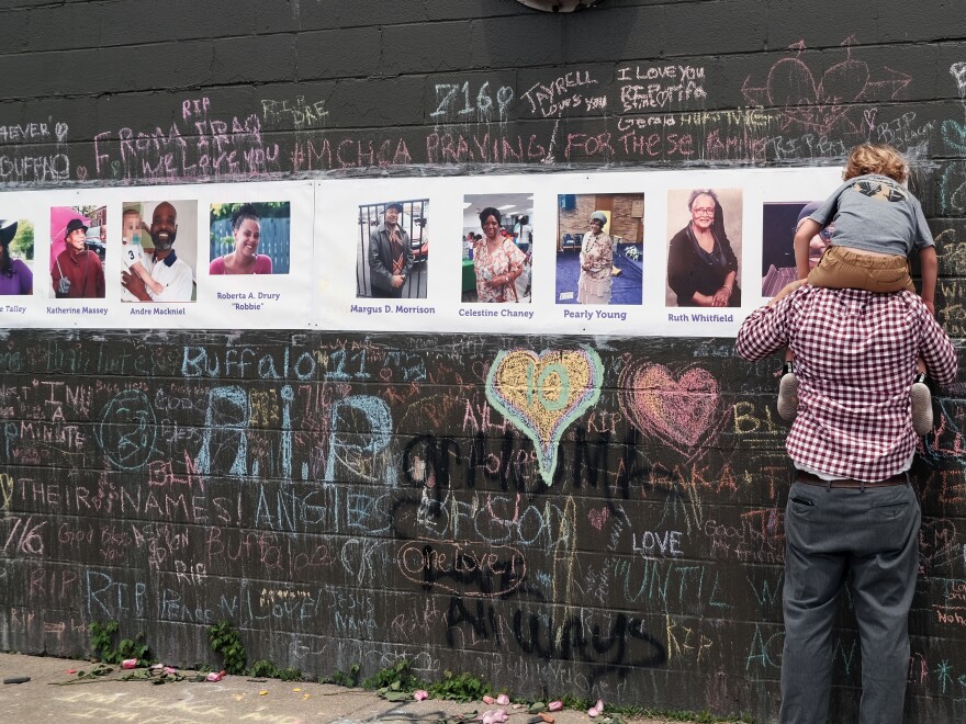 Photos of people killed in the mass shooting at Tops grocery store in Buffalo, N.Y., are part of a memorial near the store.