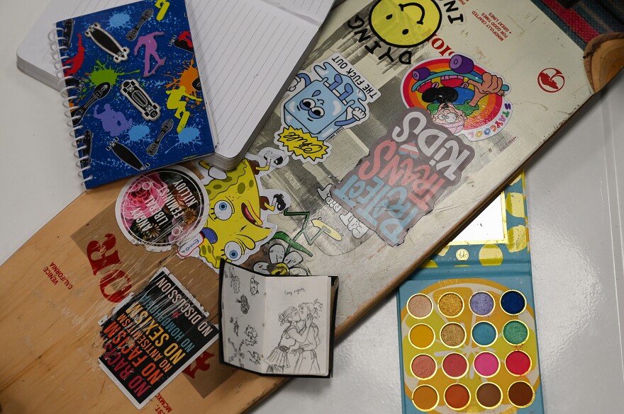 A collection of items meaningful to Julia Gonzalez, including her skateboard, notebooks, small sketchbook and eyeshadow pallet, sit on a metal table on Monday, April 15, 2024, at Main Squeeze in Columbia.