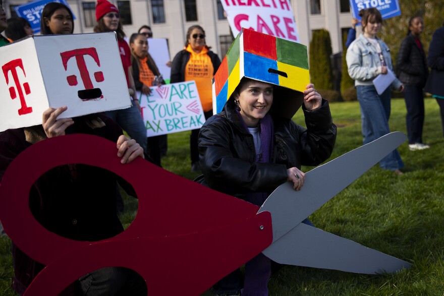 Emma LeFever, with Washington CAN, smiles before a group photo is taken following a rally against tax cuts for corporations on Thursday, February 26, 2026, at the Washington State Capitol campus in Olympia. KUOW Photo/Megan Farmer