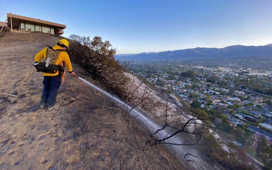 Firefighters look for hot spots Friday morning from Thursday night brush fire which damaged two homes