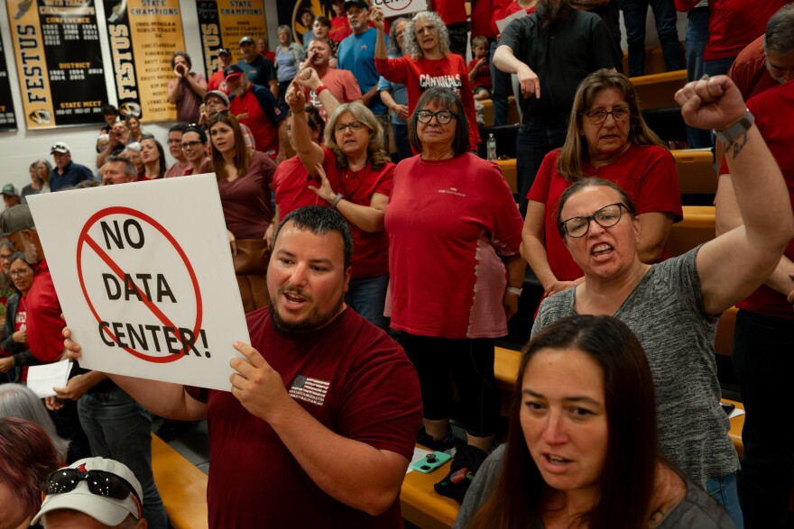 Jack Murray, lower left, of Jefferson County, joins hundreds of area residents opposing the construction of a large-scale data center in the community during a city council meeting on Monday in Festus.