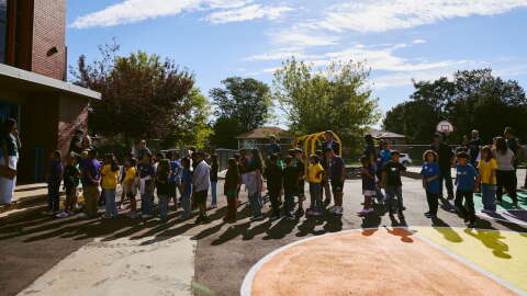 Students line up outside a playground.