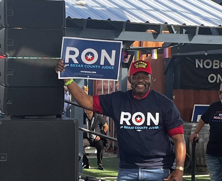A campaign staffer holds a sign at Ron Nirenberg's announcement of running for County Judge on November 15, 2025