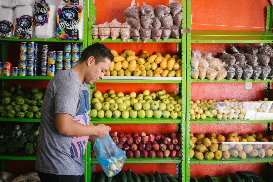 Olivas-Bejarano shops for fruit at a market in León this month. His Spanish has improved in the nearly two years he has lived in Mexico, but his American accent is noticeable among a large bilingual community.