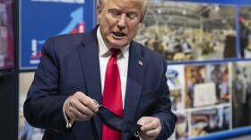 President Donald Trump holds his protective face mask as he speaks while touring Ford's Rawsonville Components Plant that has been converted to making personal protection and medical equipment, Thursday, May 21, 2020, in Ypsilanti, Mich.