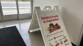 An A-frame sign, explaining SNAP and Produce Perks stands in the entrance to Gem City Market