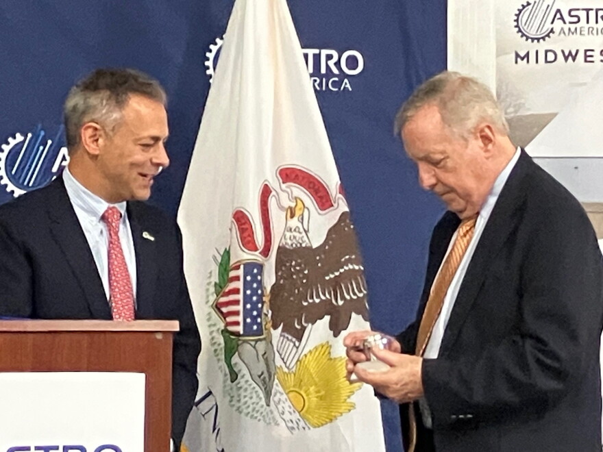 ASTRO America CEO Neal Orringer presented U.S. Dick Durbin (D-Ill.) with an ASTRO-produced replica of a military vehicle wheel hub on Thursday, in gratitude for his decades-long support of the Rock Island Arsenal and defense community in the region.