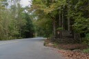 An entrance sign to Great Smoky Mountains National Park on a roadside surrounded by forest.
