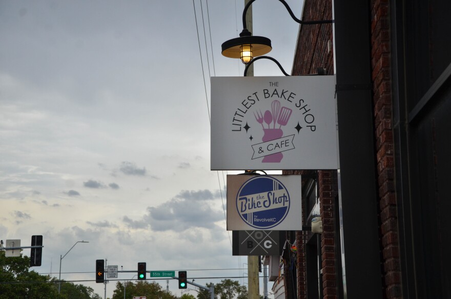 Business signs along a block say "The Littlest Bake Shop and Cafe" and "The Bike Shop."