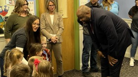 FILE - Massachusetts Secretary of Education Patrick Tutwiler (right, bending), visiting the Roots Learning Center in Westfield, Mass. on Thursday, Feb. 15, 2025.