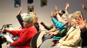 Audience members raise their hands to indicate they support funding for the Soldotna Senior Center during a Soldotna City Council meeting on Wednesday, Mar. 26, 2025 in Soldotna, Alaska.