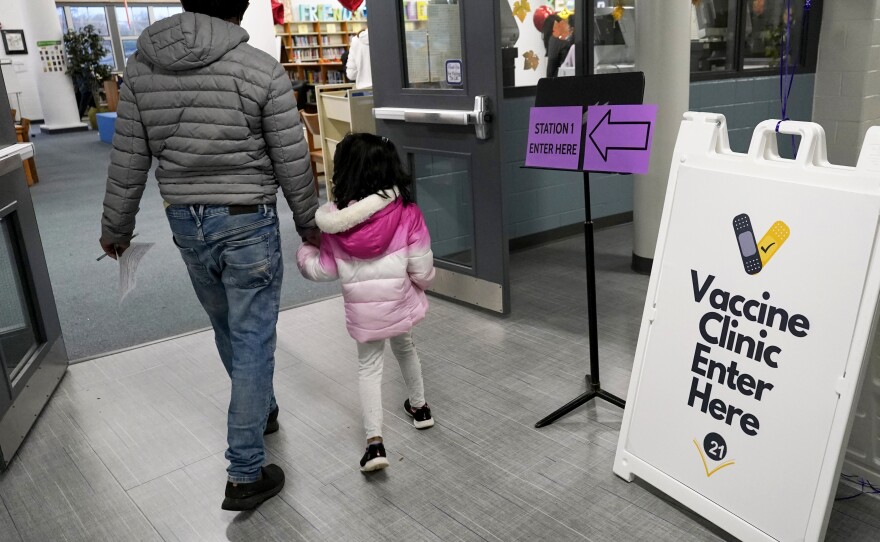 An information sign is displayed as a child arrives with her parent to receive the Pfizer COVID-19 vaccine for children 5 to 11-years-old at London Middle School in Wheeling, Ill., last month.
