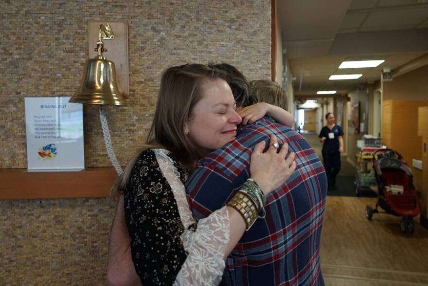 Carmen, Tom and Buck Breedlove embrace after Carmen's final chemotherapy infusion at the IU Health Simon Cancer Center.