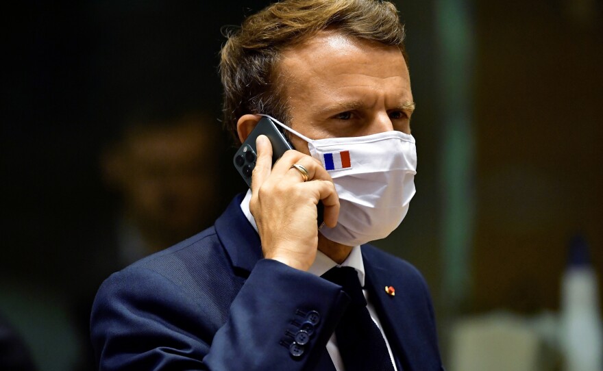 French President Emmanuel Macron speaks on his mobile phone during a meeting at a European Union summit in Brussels in July 2020. French newspaper <em>Le Monde</em> reported last month that the cellphones of Macron and other French officials in 2019 may have been among potential surveillance targets by NSO spyware.