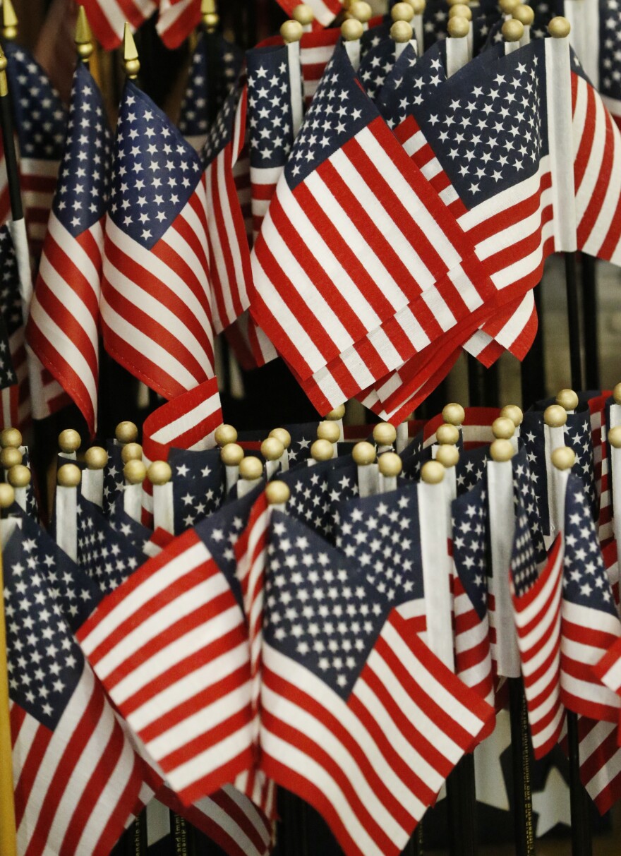 A display with American flags is shown during a naturalization ceremony at the U.S. Citizenship and Immigration Services Kendall Field Office, Thursday, Aug. 30, 2018, in Miami.