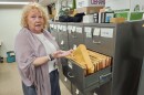 A woman pull a file out of a filling cabinet.