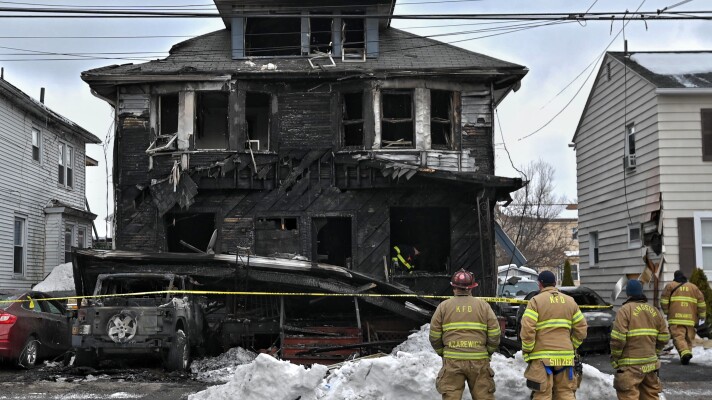 Firefighters from the Kingston Forty Fort Fire Department observe the scene of a fatal fire on N. Welles Street in Kingston.