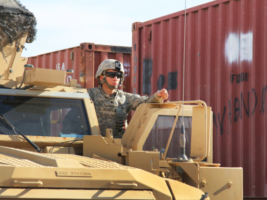 A driver of an armored vehicle waits for fuel. More than 30,000 troops have passed through the Kalsu base as the U.S. shutters its military bases in Iraq.