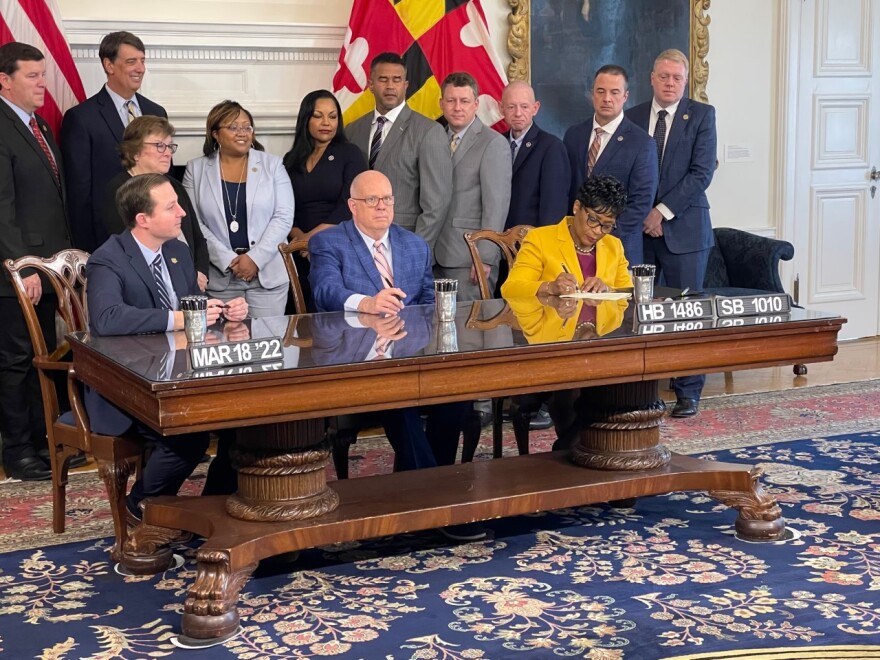 Gov. Larry Hogan (center), Senate President Bill Ferguson and House Speaker Adrienne Jones sign the gas tax holiday into law as legislative leaders look on.