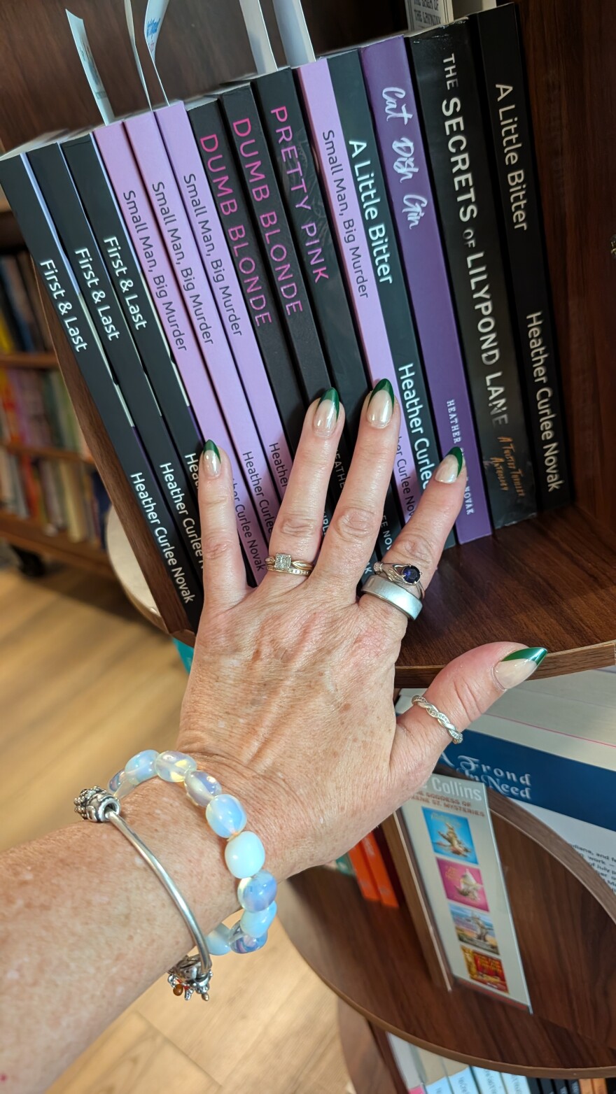 A picture of a woman's hand touching several books - all with Heather Curlee Novak as the author.