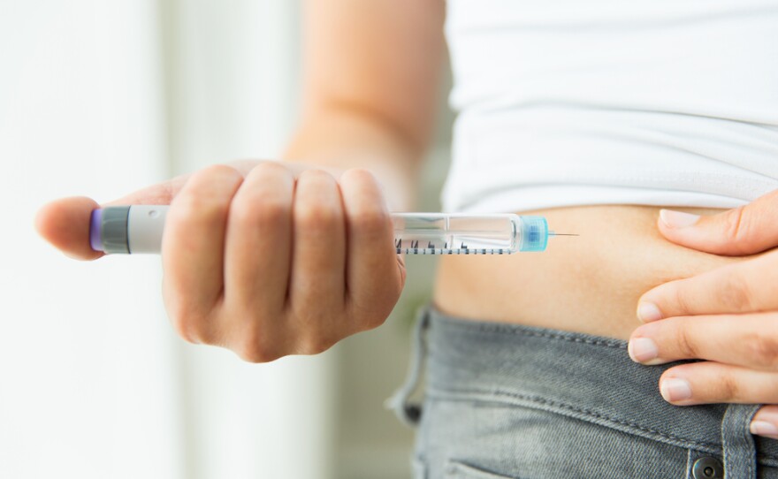 Close-up of a woman's hands making injection with insulin pen or syringe