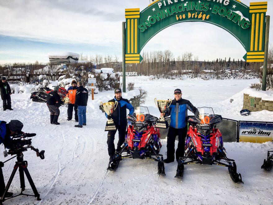 Mike Morgan and Chris Olds with their snowmachines at the Fairbanks finish line of the 2019 Iron Dog on Saturday, Feb. 23. (Photo courtesy of Tim Bodony, KIYU)