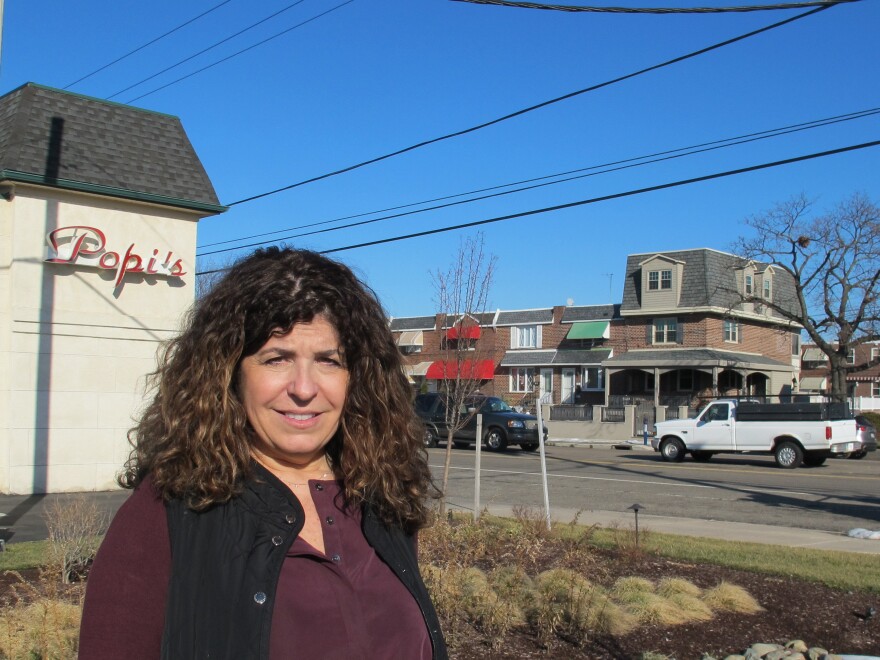 Gina Rucci stands by a new rain garden built in the parking lot of her restaurant in South Philadelphia. The improvements have cut her water runoff bill by 60 percent.