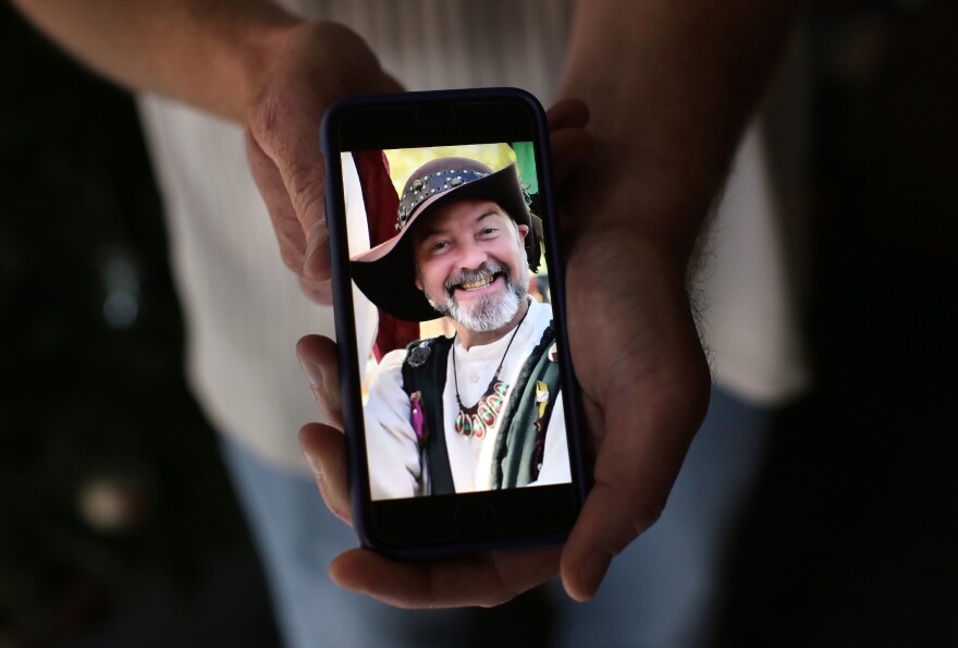 Ryan Reyes, 32, holds a photograph of his boyfriend of three years, Larry Kaufman, who was confirmed as one of the 14 people killed at the Inland Regional Center on Wednesday. The image was taken at a renaissance festival.