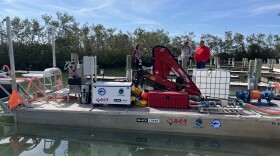 A gray boat with equipment on it for fighting red tide