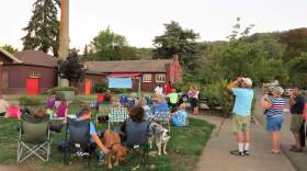 People watching birds fly around chimney.