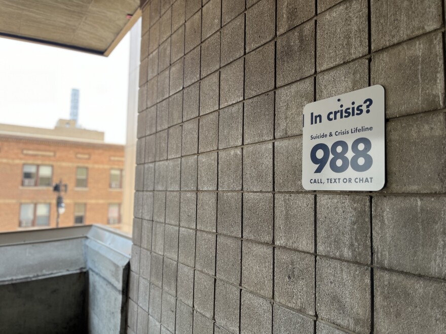 A 988 suicide and crisis lifeline placard is displayed in a parking ramp in downtown Fargo.