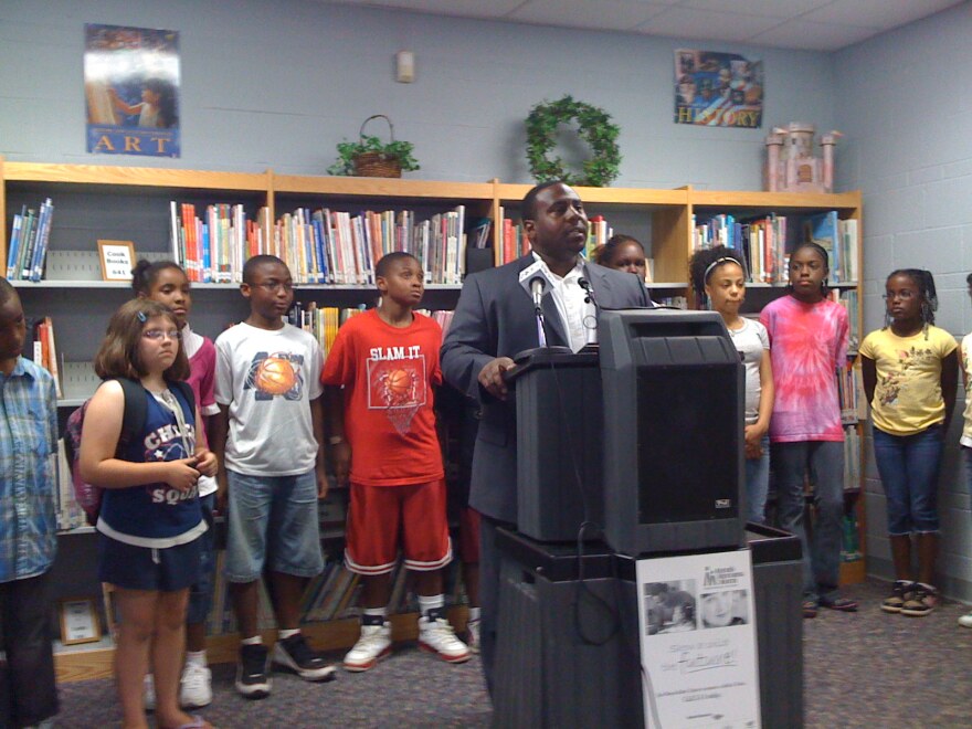 Alcott Elementary Principal Julian Wilson, surrounded by school children, discusses the grant for the Tulsa Mentoring program.