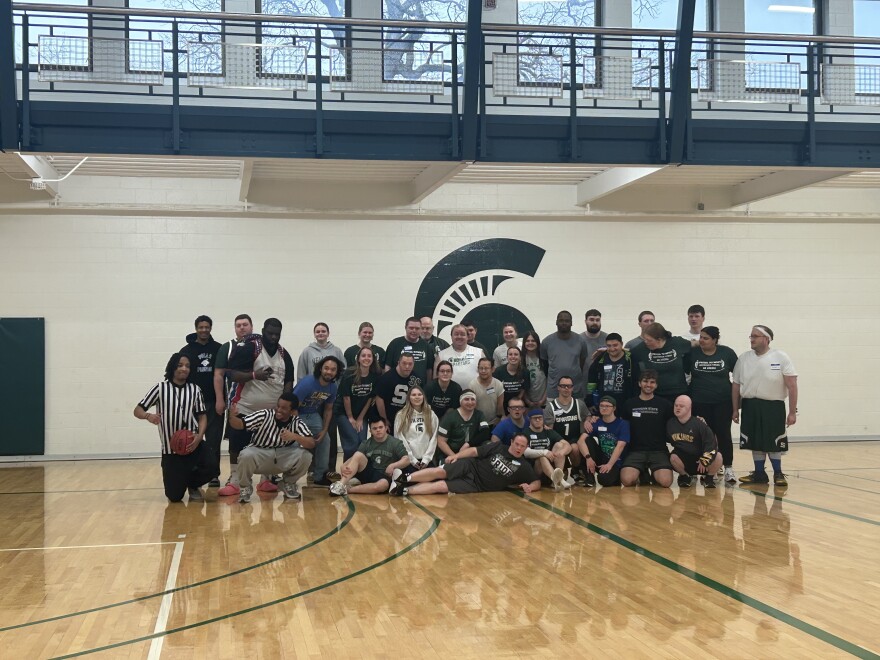 Special Olympics MSU participants, volunteers, and referees pose for a group photo at their final basketball game of the season.