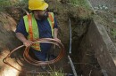 A worker with Denver Water prepares to pass a new copper water service line from a residential water meter to the water main June 17, 2021, in Denver. 