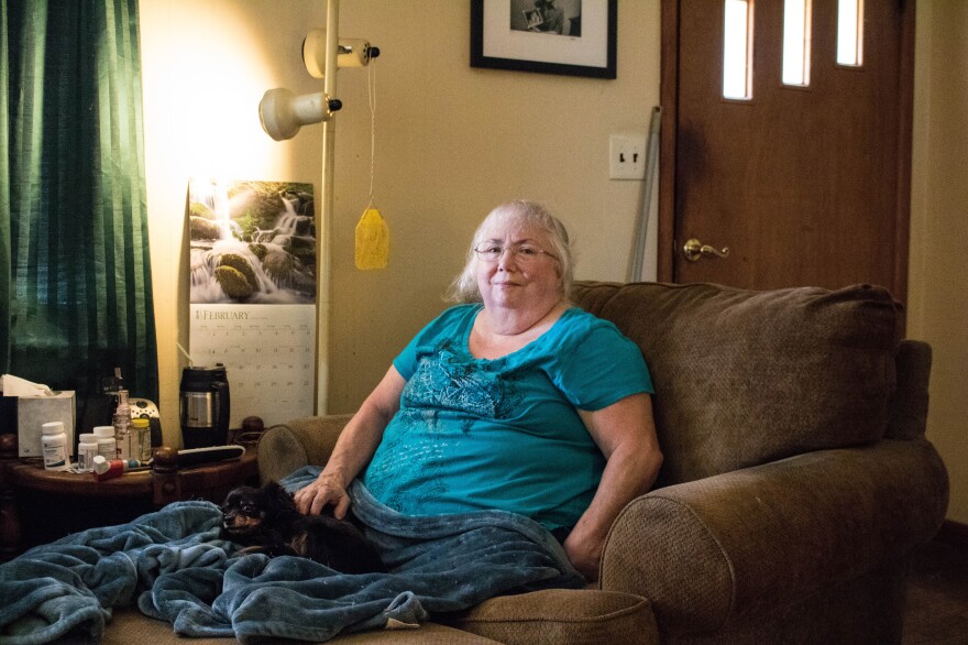 Susan Holmes sits in the living room of her home in Bokoshe, Okla. She says her asthma returned when she moved to Bokoshe, a town flanked by old coal mines.