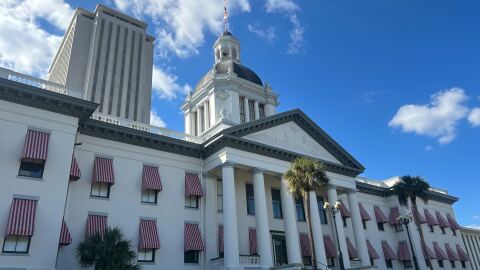 A picture of the Florida Old Capitol with the tower of the new Capitol rising in the background. Both are hit by the the sun.
