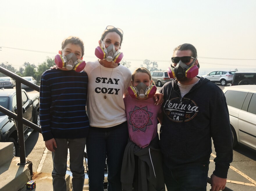 Nancy and Jay Blomquist stand outside the Local Assistance Center in Ventura, Calif., with their twins, Alexander and Olivia. The family wears masks to protect themselves from the ash and smoke in the air from the Thomas Fire.